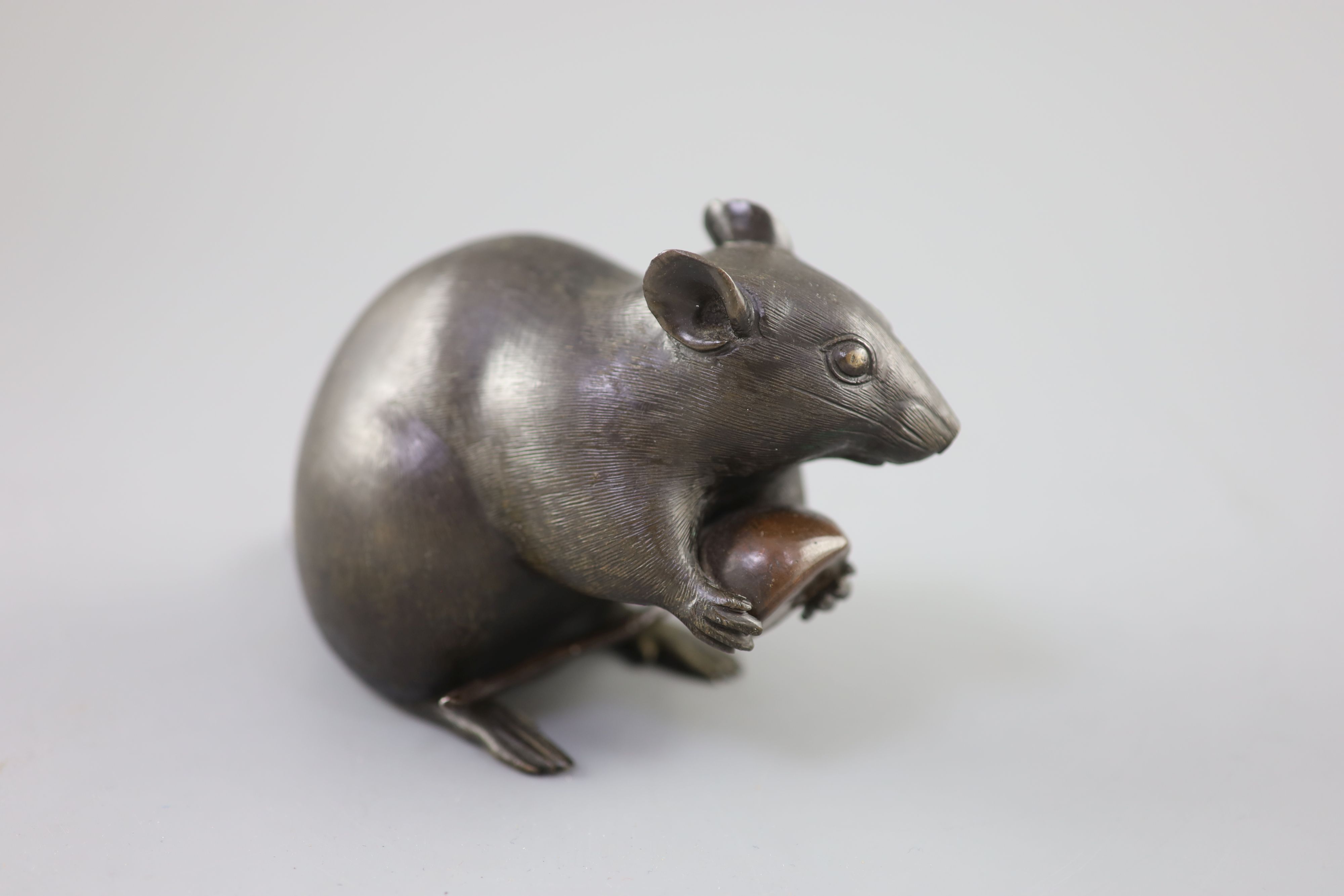 A Japanese bronze model of a rat holding a chestnut, Meiji period, 17cm long